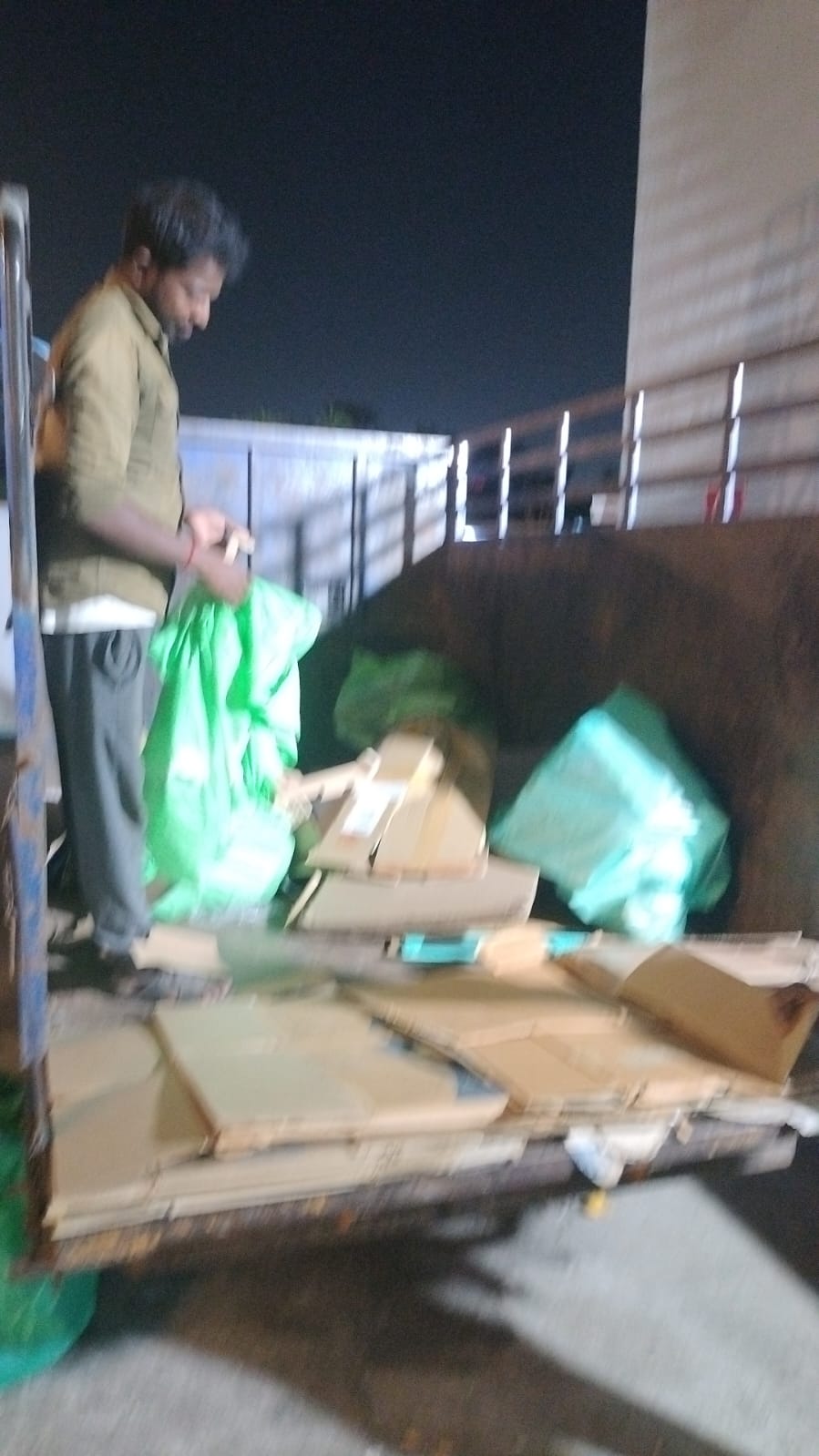 Night-time scrap and bag loading on collection truck